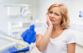 A concerned woman with dental issue at a dentistry.